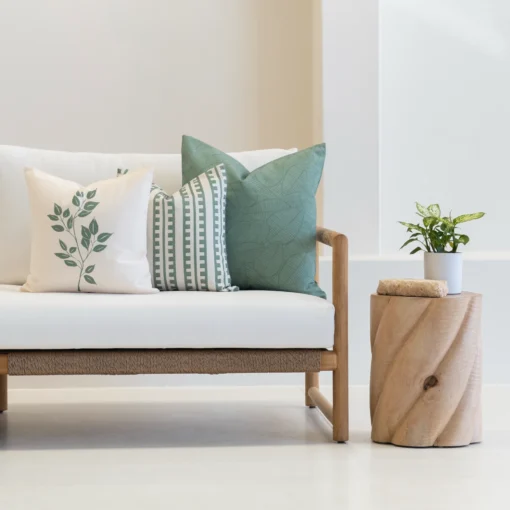 Outdoor living room showcasing 3 sagewood outdoor couch cushions on a white couch.
