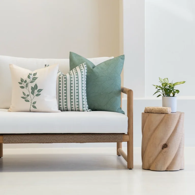 Outdoor living room showcasing 3 sagewood outdoor couch cushions on a white couch.
