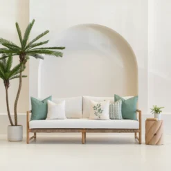 A set of 5 sagewood coloured outdoor sofa cushions sitting on a white sofa.