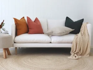 Four colour cushions styled on a white sofa.