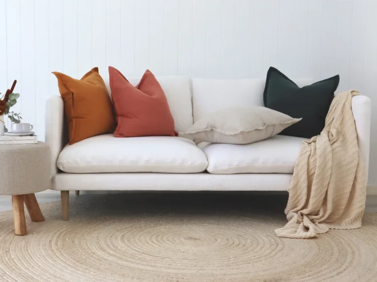 Four colour cushions styled on a white sofa.
