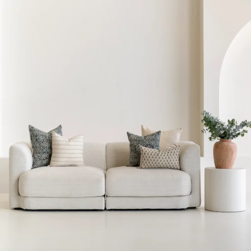 Living room scene with 5 designer sofa cushions arranged on a sofa.