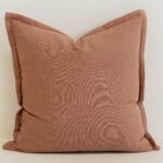 Close-up of Clay linen cushion in warm terracotta tone with soft texture.