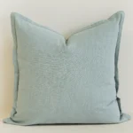 Close-up of eucalyptus blue linen cushion with soft textured finish.