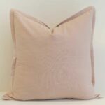 Blush linen cushion cover with a soft flange edge and a light, airy tone.