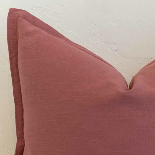 Close-up of dusty pink linen cushion corner with neat stitched edge