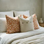 Marenca ginger cushions styled on bed with floral patterns and neutral button accent cushion.