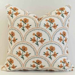 Floral scallop cushion cover with warm ochre blooms set within a soft geometric lattice.