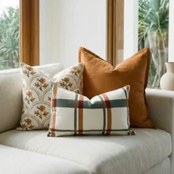 Marenca plaid cushions styled on beige sofa with check pattern and neutral tones.