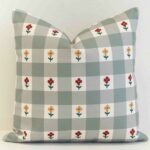 Gingham check cushion cover in muted sage tones with small scattered floral details for a gentle, country feel.