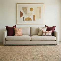 Marenca tan cushions on beige sofa with neutral tones and geometric wall art.