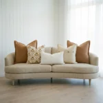 Marenca tan cushions arranged on sofa with floral and textured neutral designs.