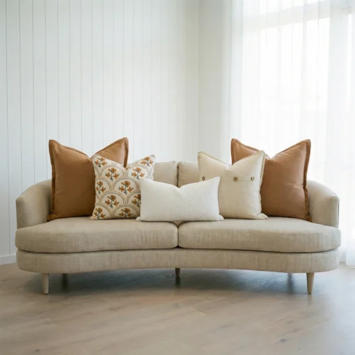 Marenca tan cushions arranged on sofa with floral and textured neutral designs.