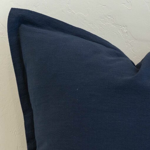 Close-up of navy blue linen cushion corner with a soft flange edge detail.