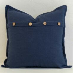 Navy linen button cushion cover featuring natural wooden buttons for a relaxed, refined detail.