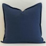 Navy linen button cushion cover with natural wooden buttons on the reverse, adding a thoughtful, textural detail.
