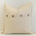 Oatmeal linen button cushion cover finished with wooden buttons for a warm, understated accent.