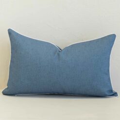 Pacific blue rectangular cushion with white piping on plain background.