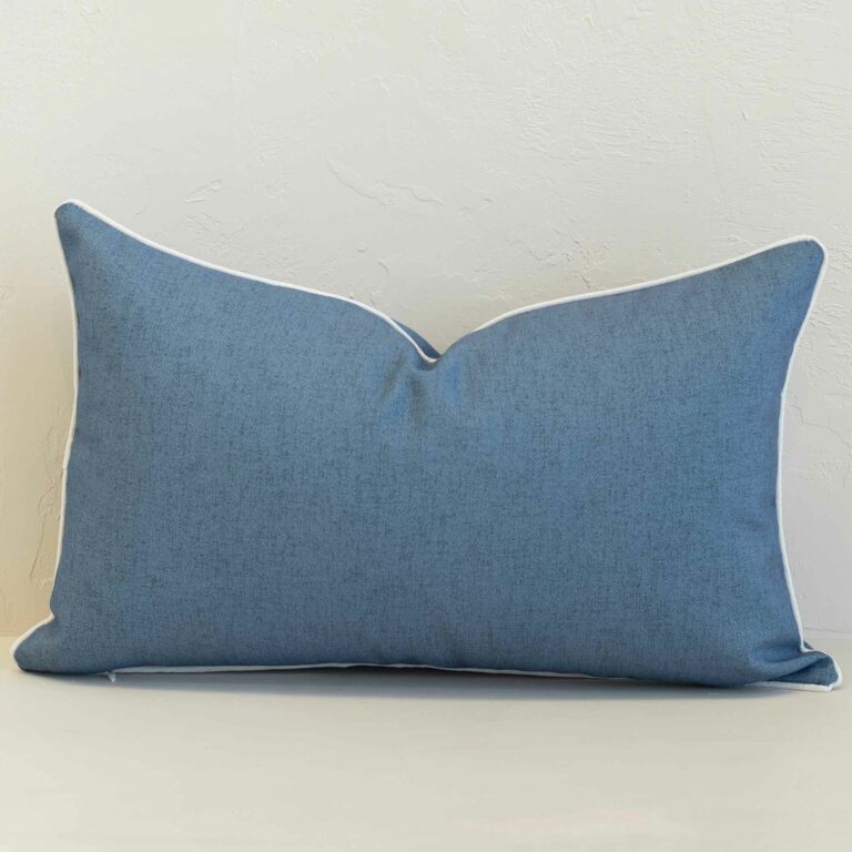 Pacific blue rectangular cushion with white piping on plain background.