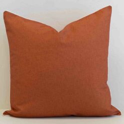 Pacific rust square cushion with subtle texture and white piping edges.