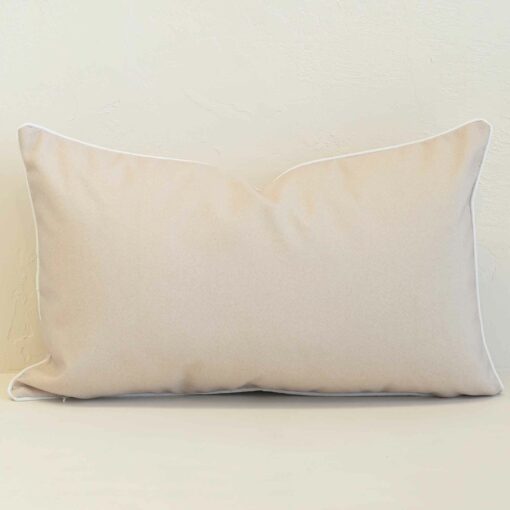 Pacific sand rectangular cushion with plain design and white piping edges.