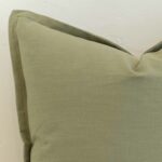 Close-up of sage linen cushion corner with subtle flange edge and soft structured finish.