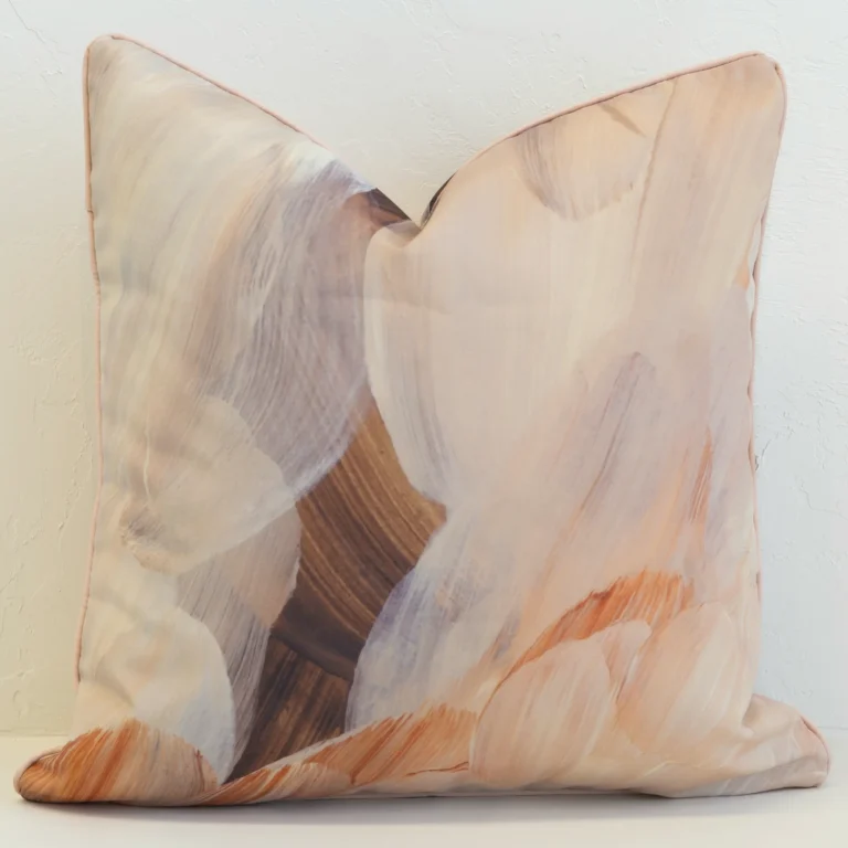 A handprinted abstract brown outdoor cushion with broad brushstrokes in brown, beige and dusty pink tones.