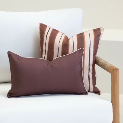 Solterra cushions in brown and blush tones with stripe and plain designs on sofa.