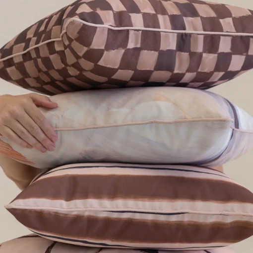Close-up of Solterra cushions showing layered stripes, checks and painterly textures.