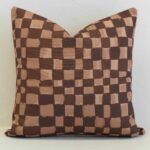 Checkered outdoor cushion cover in layered brown and tan tones, bringing a modern, hand-painted feel with subtle texture.