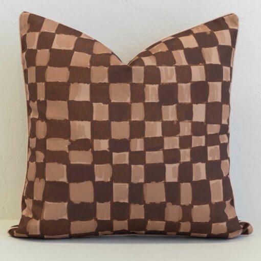 Checkered outdoor cushion cover in layered brown and tan tones, bringing a modern, hand-painted feel with subtle texture.