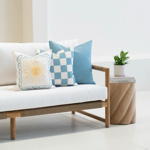 Tropica aqua cushions with sun motif and check pattern styled on sofa.