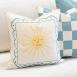 Close-up of Tropica aqua cushion with sun motif and blue border.
