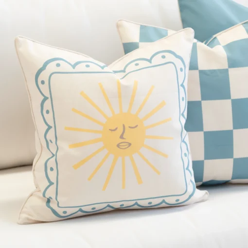 Close-up of Tropica aqua cushion with sun motif and blue border.