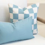 Close-up of Tropica aqua cushions with blue check pattern and plain cushion.