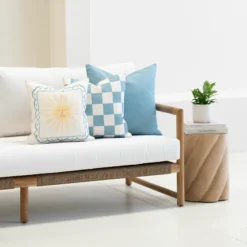 Tropica aqua cushions with sun motif, check pattern and plain blue on sofa.