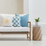 Tropica aqua cushions set with sun motif and check pattern on sofa.