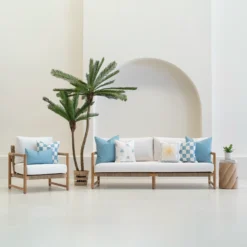 Tropica aqua cushions set with palm, sun and check patterns on sofa.
