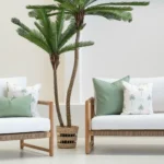 Tropica green cushions styled on outdoor sofa with palm tree backdrop.
