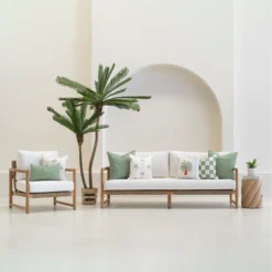 Tropica green cushions styled across sofa and chair with tropical patterns.