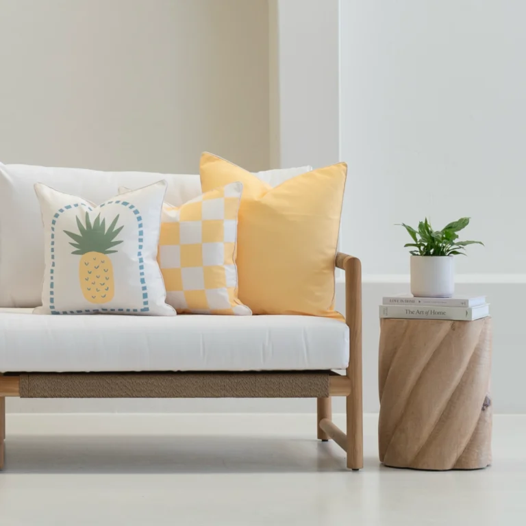 Tropica lemon yellow cushions with pineapple and check patterns on sofa.