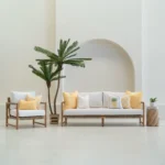 Tropica lemon yellow cushions styled on sofa and chair in outdoor setting.