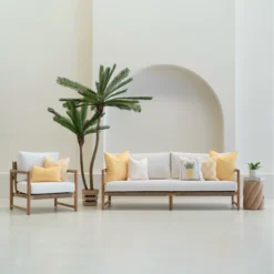 Tropica lemon yellow cushions styled on sofa and chair in outdoor setting.