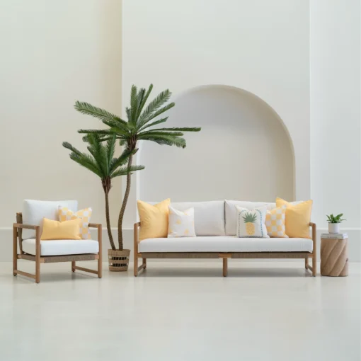 Tropica lemon yellow cushions styled on sofa and chair in outdoor setting.