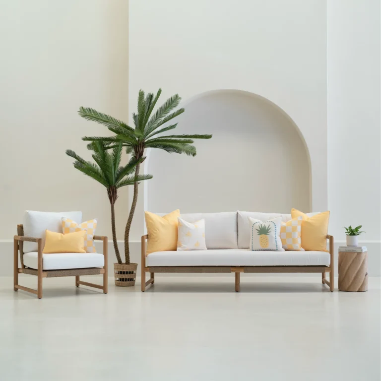 Tropica lemon yellow cushions styled on sofa and chair in outdoor setting.