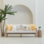 Tropica lemon yellow cushions arranged on outdoor sofa with fruit motif designs.