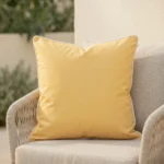 Plain lemon yellow Tropica cushion with white piping on outdoor armchair.
