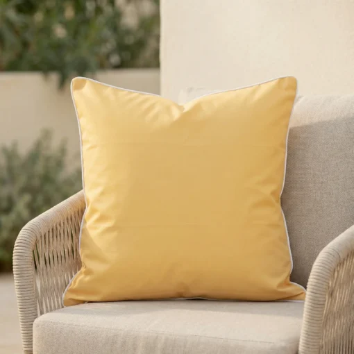 Plain lemon yellow Tropica cushion with white piping on outdoor armchair.