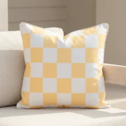 Tropica lemon yellow check cushion with soft white squares on sofa.