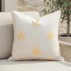 Tropica lemon yellow cushion with palm tree pattern on outdoor seating.